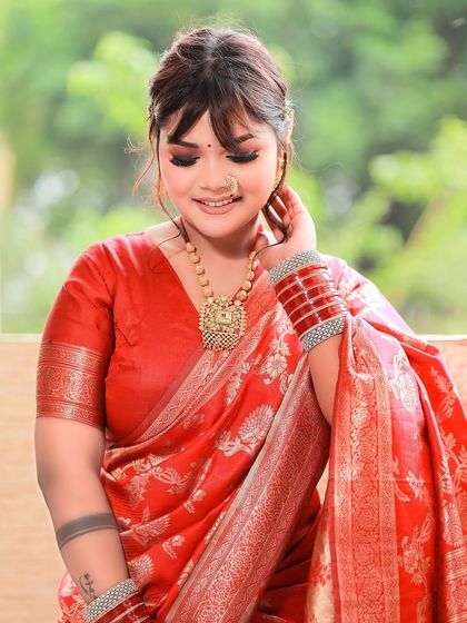 A beautiful portrait in a red Banarasi saree, shot in natural light for a soft, classic feel.