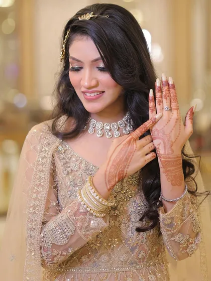Showing off the ring and the beautiful henna. The makeup is flawless, ensuring she's ready for all the close-up shots.