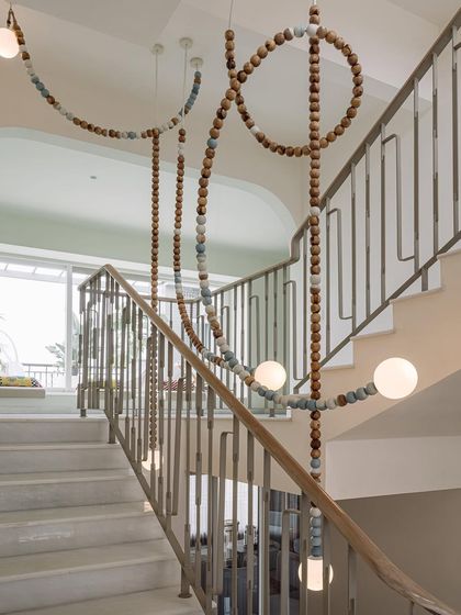 A close-up of the 'Luna' light installation, showing the detail of the wooden and ceramic beads that make up this stunning, meandering fixture.