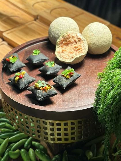 A unique presentation of our charcoal-infused appetizers. The deep black of the charcoal dough contrasts beautifully with the vibrant colours of the fillings and surrounding fresh vegetables.
