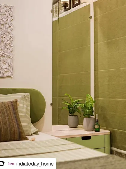 A shot of the master bedroom from our feature in India Today Home. The room features a soothing green color palette, a custom headboard, and a beautiful carved wood art piece.
