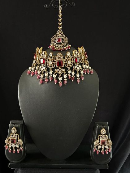 This red Victorian choker set is perfect for a bold reception look. The set includes the choker, matching earrings, and a maang tikka.