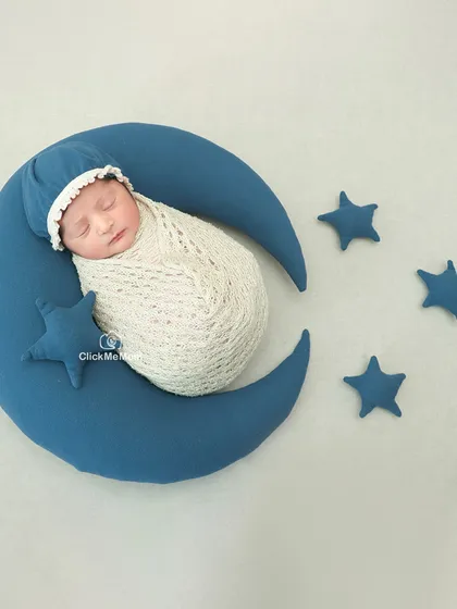I love you to the moon and back. This celestial theme features a baby sleeping on a crescent moon prop, surrounded by soft blue stars.