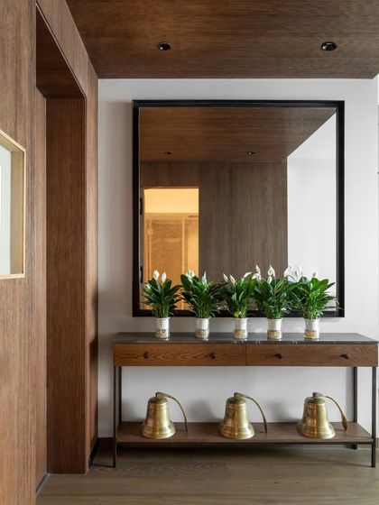 The entrance to the family lounge is marked by this simple yet elegant console table from our Koko collection. Adorned with a row of peace lilies and antique temple bells, it sets a tone of understated comfort and mindful design.
