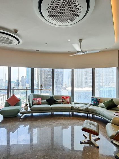 Another angle of the Jesrani Residence living room, highlighting the custom wall niches and the gentle curve of the space. The design ensures that every part of the room benefits from the incredible view and abundant daylight.