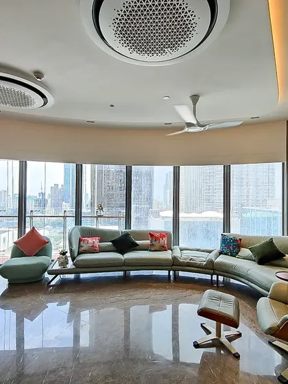 Another angle of the Jesrani Residence living room, highlighting the custom wall niches and the gentle curve of the space. The design ensures that every part of the room benefits from the incredible view and abundant daylight.