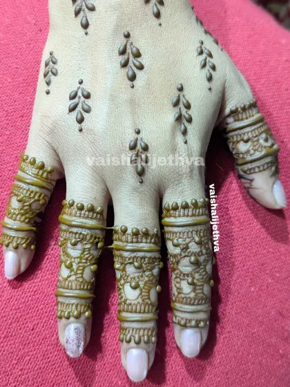 A very simple and elegant design. The back of the hand has delicate leafy vines, while the fingers have intricate bands.