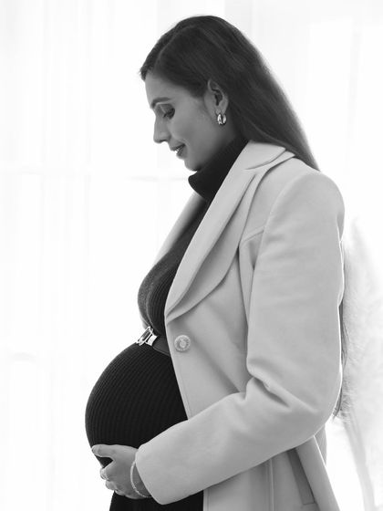 A soft and contemplative black and white portrait. The side profile against a bright window creates a beautiful, natural light silhouette that is both artistic and serene.