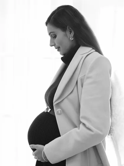 A soft and contemplative black and white portrait. The side profile against a bright window creates a beautiful, natural light silhouette that is both artistic and serene.