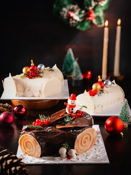 A trio of our Bûche de Noël (Yule Log) cakes, available in both dark chocolate and white chocolate versions. Each is beautifully decorated with festive elements, offering a choice for every palate.