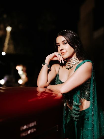 A sultry and sophisticated sangeet look. The bride's emerald green saree is complemented by a soft, glowing makeup look that is perfect for a glamorous evening.