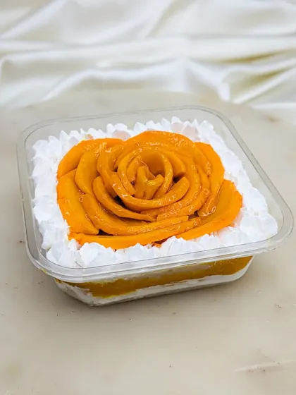 Our Mango Fresh Cream cake is also available in a tub. It's layered with our signature vanilla sponge, light cream, homemade aamras, and diced mangoes for a perfect summer treat.