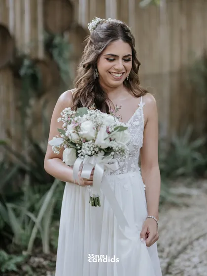 The bride, Trisha, in her beautiful white wedding gown, holding her bouquet. A simple, elegant portrait filled with happiness.