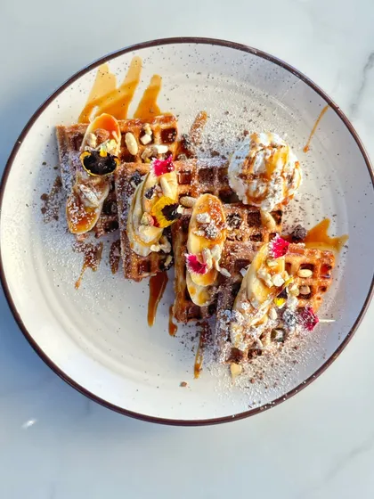 Our signature waffles are a feast for the eyes and the taste buds. Topped with fresh bananas, berries, crunchy nuts, a scoop of vanilla ice cream, and a drizzle of caramel sauce, it's the perfect treat to share or enjoy all to yourself.