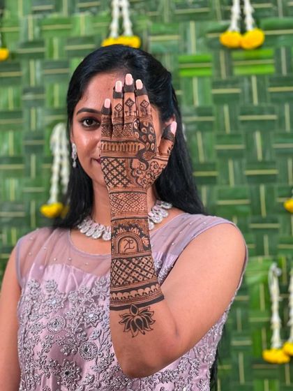 A classic mehendi pose, with the client holding her hand up to her face. It's a great way to show off the design on the arm.