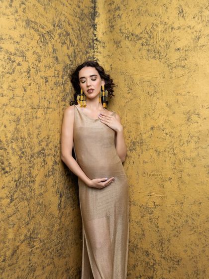 Every mother deserves a moment to shine, and this one is pure gold. The textured gold background and shimmering dress create a luxurious and artistic portrait.