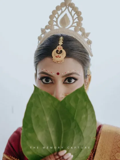 We celebrate and understand the beauty of diverse traditions. This iconic shot from a Bengali wedding captures the bride's striking eyes over the betel leaves, a moment of suspense and tradition that we frame with artistic reverence.
