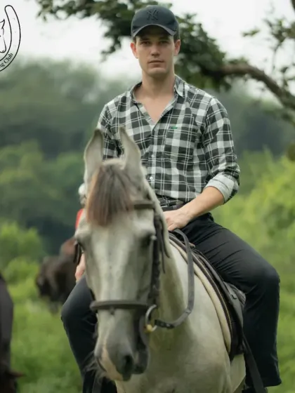 A focused rider on a beautiful grey horse, surrounded by the lush greenery of the Aravallis. This portrait captures the calm and composed atmosphere of our trail rides.