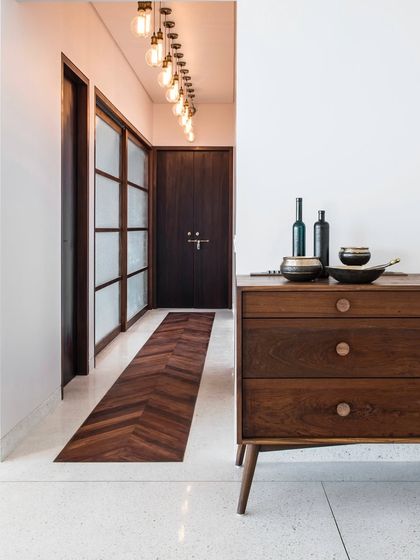 In the Terrazzo Residence, we used a wooden inlay in a herringbone pattern to define the entrance passage, creating a visual distinction from the cast-in-situ terrazzo floor of the main living area.