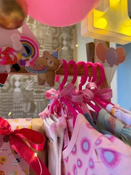 Tiny dresses on pink hangers, adorned with cute bear cutouts. This isn't just a gift; it's a miniature closet of dreams.