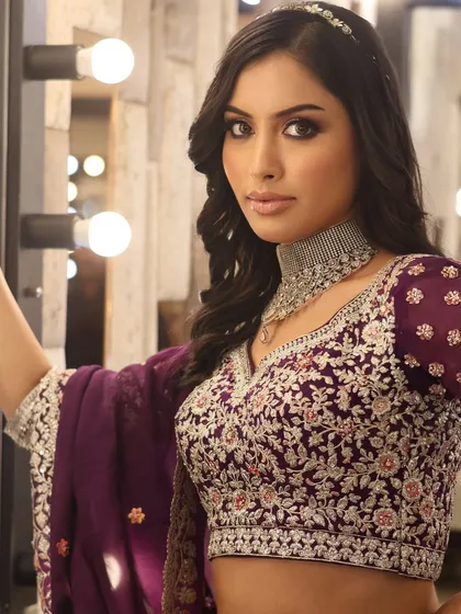 This pose showcases the intricate embroidery of the blouse and how the diamond choker sits. We discuss how makeup choices are influenced by the outfit's neckline and style.