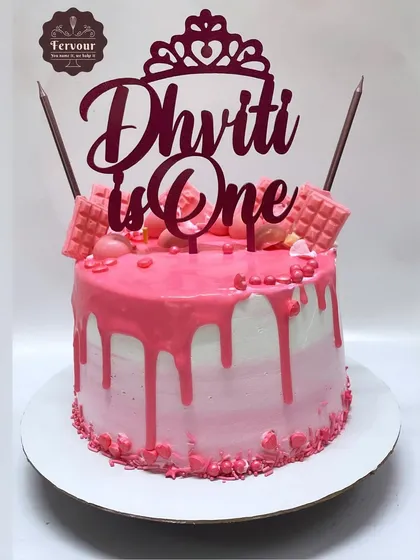 A "Dhviti is One" cake for a first birthday. This vanilla strawberry cake has a pink ombre design with a drip effect and a custom topper.