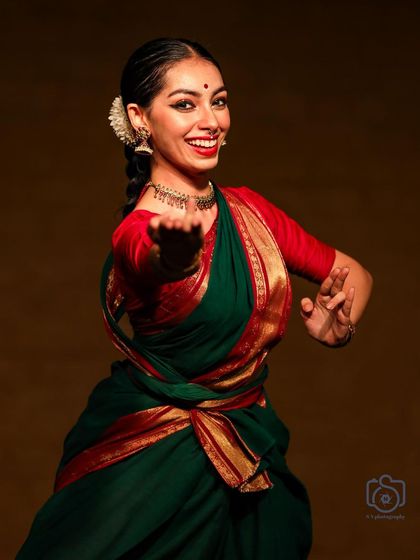 A joyful and open expression, inviting the audience into the performance. My goal is to make classical dance feel accessible and full of life.