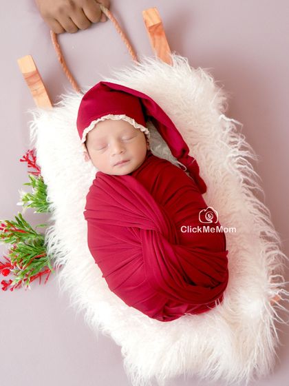 A perfect little gift for the holiday season. This Christmas-themed shoot features a baby in a Santa hat, nestled cozily on a miniature sleigh.