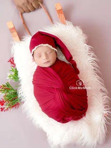 A perfect little gift for the holiday season. This Christmas-themed shoot features a baby in a Santa hat, nestled cozily on a miniature sleigh.