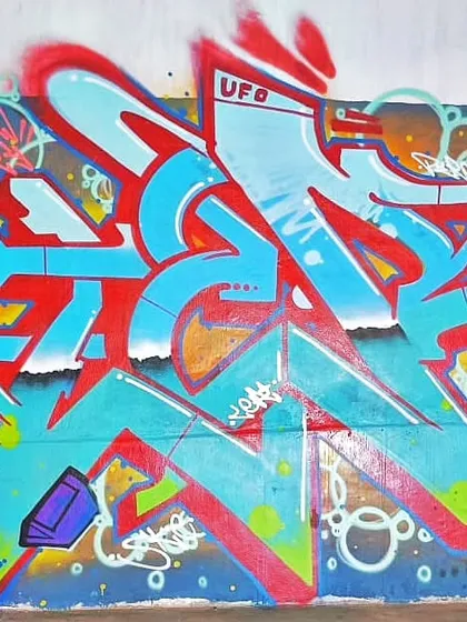 A slightly different angle of the same collaborative wall, highlighting the energy and density of the artwork.