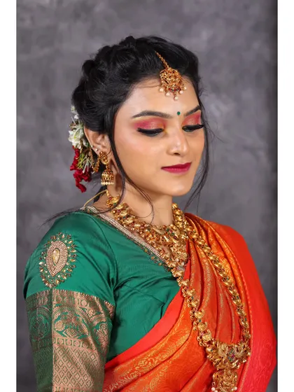 A serene portrait capturing the fine details of the saree's border and the intricate gold jewelry.