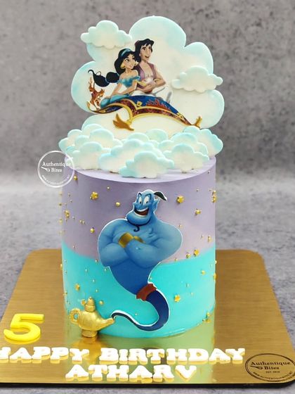 An Aladdin-themed cake featuring Genie, Aladdin, and Jasmine on their magic carpet ride. The purple and teal colors perfectly capture the magic of the movie.