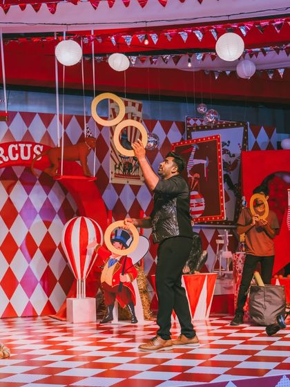 A juggler entertains the crowd on the checkered circus stage. Live performances add energy and a sense of spectacle to any event.