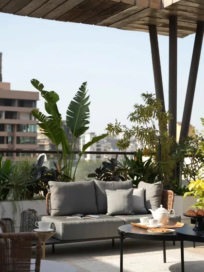 A detail of the terrace seating, perfect for enjoying a morning croissant and coffee. The design focuses on creating a comfortable and inviting atmosphere for outdoor living.