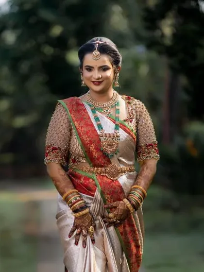 A stunning bride in a silver and red saree, her rich mehendi stain adding to her regal look.