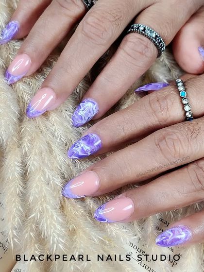 An enchanting design featuring purple marble art on the tips in a French manicure style. The intricate white veins within the purple marble create a sophisticated and artistic look.