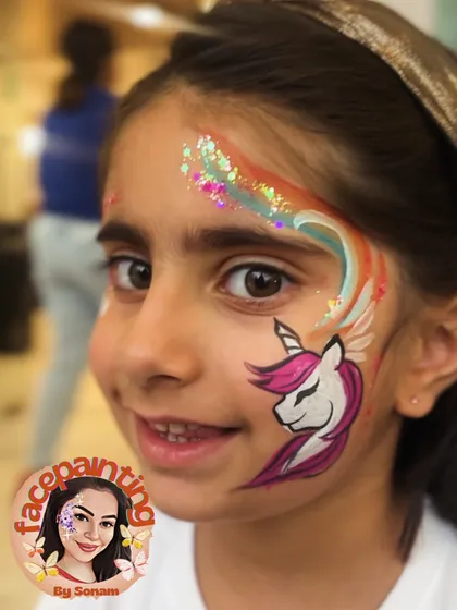 A happy girl with her unicorn and rainbow face paint. This design is always a crowd-pleaser.