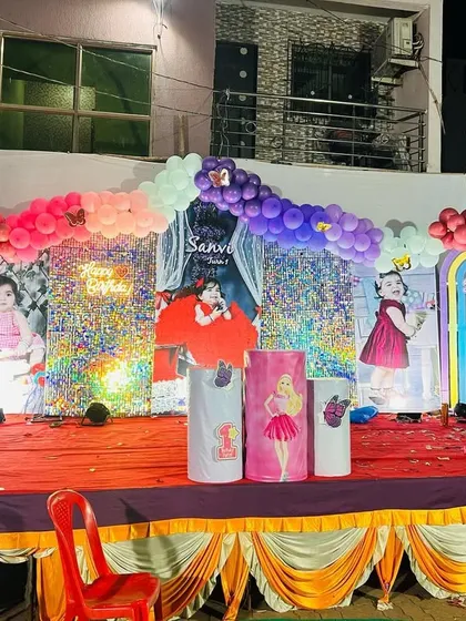 A closer look at the princess-themed outdoor stage decoration. It features large photo backdrops of the birthday girl, character cutouts, and a colorful balloon arch.
