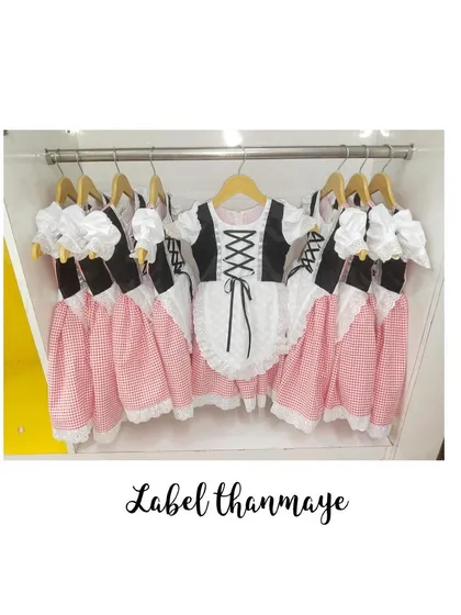 A set of matching European-style folk dresses, featuring gingham skirts and corset-style tops, ready for a themed school performance. This shows how I prepare bulk orders.