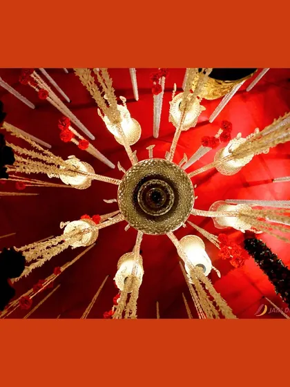 A view from below of a stunning red and gold chandelier. The intricate details and warm lighting add to the luxurious and regal atmosphere of the event.