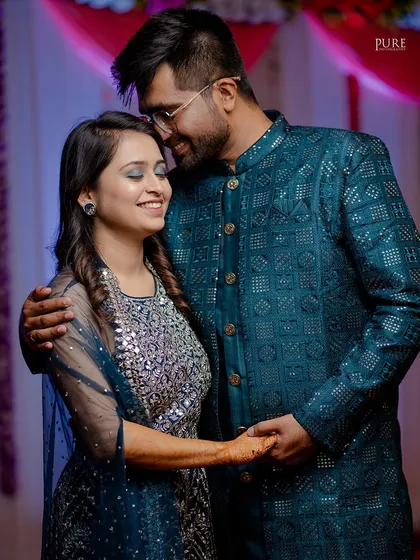 A sweet and happy moment from an engagement ceremony. The couple's smiles and gentle hold show their excitement for the future.