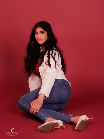 A dynamic floor pose that showcases her long lines and the stylish combination of blazer and jeans.