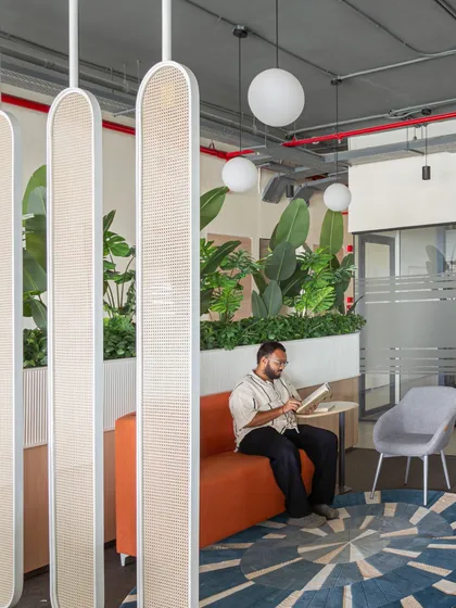 A team member enjoying a moment of quiet focus in the central breakout area. The design proves that even in the heart of a busy office, you can create pockets of tranquility.
