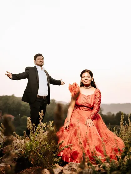 A joyful and dynamic maternity shoot in the hills. This red-orange gown with a unique sleeve design adds a vibrant pop of color to the natural scenery.