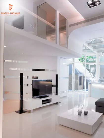 The living area in this modern home features a sleek TV unit and a double-height ceiling with glass, which floods the space with natural light.