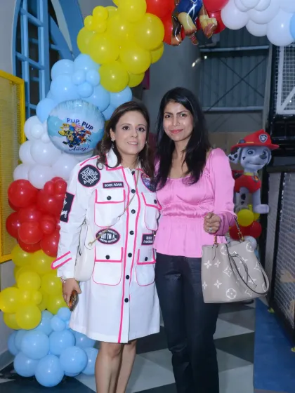 Two moms enjoying the Paw Patrol themed party while the kids play.