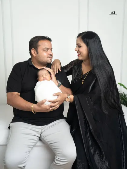 The beginning of a new life as a family. The parents look at each other with so much love while the father gently cradles their sleeping newborn.
