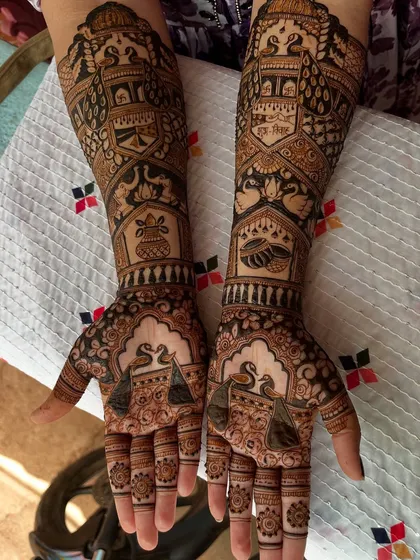 The front view of a bridal mehendi, showcasing swans and other traditional motifs. The fingertips are kept dark and solid, which creates a beautiful contrast and is considered auspicious.