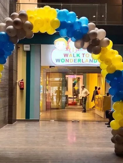 A large balloon arch in Minion-themed colors creating a grand entrance to the party venue.