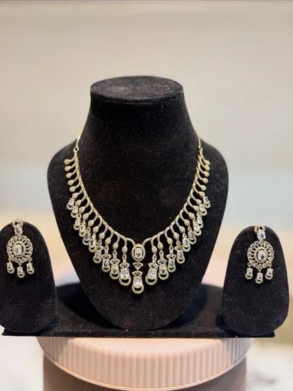 Our rose gold plated diamond necklace and earring set, displayed on a bust. This is a simple yet stunning set, perfect for those who love modern elegance.